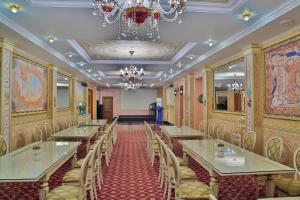a dining room with tables and chairs and a chandelier at The Amsterdam Boutique Hotel in Aktobe