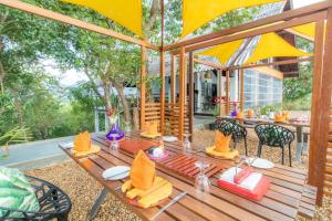 KiralagollaElephant Stables Dambulla的一张带椅子的木桌和一把伞