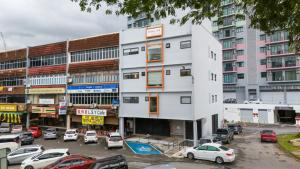a white building with cars parked in a parking lot at Kenny Hill Boutique Hotel near Borneo Medical Centre Kuching in Kuching