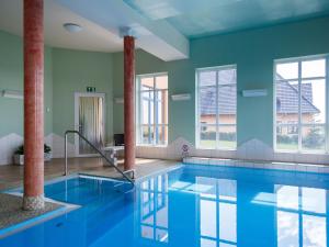 马克莱贝格Holiday home in Markkleeberg near a lake的一座带窗户的建筑里,有一个蓝色的游泳池