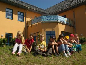 马克莱贝格Holiday home in Markkleeberg near a lake的一群孩子坐在建筑物前的草地上 更多29张照片