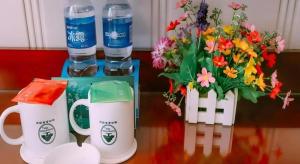 un tavolo con due tazze da caffè e un mazzo di fiori di GreenTree Inn MaAnshan Economic Development District Hongqi South Road Express Hotel a Gangzi Altre 154 foto