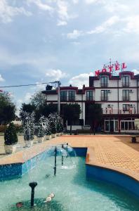 un bâtiment avec une piscine en face d'un bâtiment dans l'établissement Taxi Bar Motel, à Gradiška