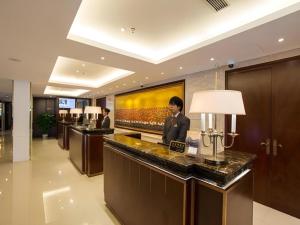 eine Hotellobby mit einem Mann, der an einem Tresen steht in der Unterkunft Jinjiang Metropolo Shanghai Minhang in Shanghai