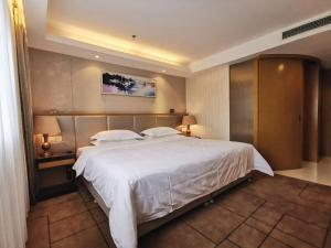 ein Schlafzimmer mit einem großen weißen Bett mit zwei Kissen in der Unterkunft Jinjiang Metropolo Shanghai Minhang in Shanghai + 266 Fotos