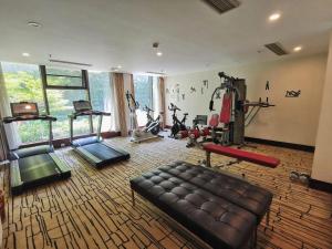ein großer Raum mit einem Fitnessraum mit Couch und Trainingsgeräten in der Unterkunft Jinjiang Metropolo Shanghai Minhang in Shanghai