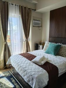 ein Schlafzimmer mit einem großen Bett und einem Fenster in der Unterkunft Twinlakes Tagaytay Vinesera Manor1 3F in Balibaguhan