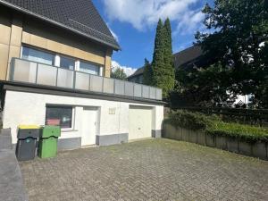 een huis met twee vuilnisbakken ervoor. bij Ferienwohnungen Thingslinde in Kierspe