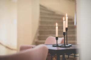 ein Tisch mit zwei Kerzen darauf und Stühlen in der Unterkunft Alte Försterei Wildenthal in Eibenstock