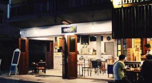 un uomo seduto davanti a un ristorante con un tavolo di Remember Loei Love a Chiang Khan