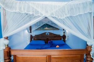 ein Bett mit Baldachin in einem blauen Schlafzimmer in der Unterkunft Hotel Blue Sapphire in Aluthgama