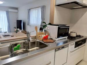 a kitchen with a sink and a microwave at 馥の森 in Kumamoto +67 photos