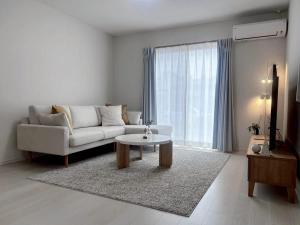 een woonkamer met een bank en een salontafel bij 馥の森 in Kumamoto