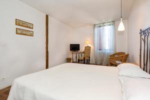 Postel nebo postele na pokoji v ubytování Logis Hôtels - Hôtel Restaurant du Midi