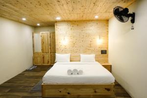 een slaapkamer met een bed met twee schoenen erop bij Kings Holidays Munnar in Ūdumbanshola