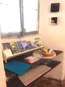uno scaffale con sopra dei libri accanto a una finestra di La Ca' Vegia a Stresa