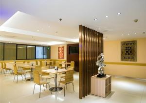 ein Restaurant mit gelben Stühlen und Tischen und einer Lobby in der Unterkunft City Comfort Inn Guilin Lingui Jinshan Square in Lingui