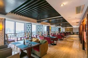 un ristorante con tavoli, sedie e finestre di SSAW Boutique Hotel Shaoxing Ancient Town a Dongpu