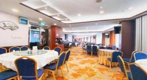 a conference room with tables and chairs in a room at Towns Well Motel in Macau