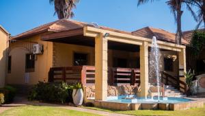 ein Haus mit einem Brunnen davor in der Unterkunft EGB Guest House in Springs