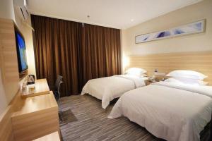 una camera d'albergo con due letti e una televisione di City Comfort Inn Nanning Normal University Changgang Road Metro Station a Nanning