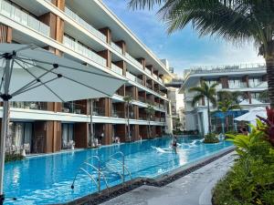 a swimming pool at a resort with a person in the water at Sunshine Layan Beach Resort studio #84191 in Layan Beach