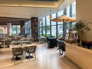 a restaurant with tables and chairs and windows at Sunshine Layan Beach Resort studio #84191 in Layan Beach