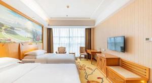 Vienna Classic Hotel Qingdao Huangdao في هوانغادو: غرفة فندقية بسريرين وتلفزيون بشاشة مسطحة