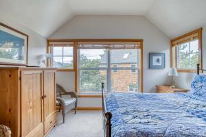 a bedroom with a bed and a chair and a window at BeachLovers Getaway in Pacific City