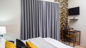 ein Schlafzimmer mit einem Bett und einem grauen Vorhang in der Unterkunft EGB Guest House in Springs