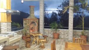 a patio with a fireplace and a table and chairs at Tea Hills Bungalow in Hatton