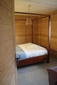 a bedroom with a bed in a wooden wall at Chalet Eterlou in Mégevette +29 photos
