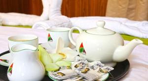 MaththalaBestlife Eco Resort Mattala Airport的桌子上有两个杯子和一个放在盘子上的茶壶