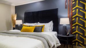 ein Schlafzimmer mit einem großen Bett mit gelben Kissen in der Unterkunft EGB Guest House in Springs