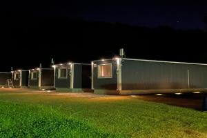 八幡平市MOBILITA COURT IWATE的夜幕下，一排绿色的小屋亮着灯。