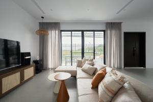 Una sala de estar con un sofá y un televisor. en 澤木行旅 The Riverwood, en Yilan City