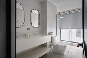 Un baño blanco con lavabo y espejo. en 澤木行旅 The Riverwood, en Yilan City 16 fotos más