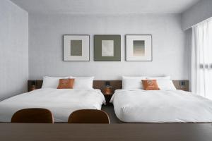 Dos camas una al lado de la otra en una habitación. en 澤木行旅 The Riverwood, en Yilan City