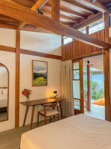 Japanese Villa في كوتا لومبوك: غرفة نوم بها سرير ومكتب وطاولة