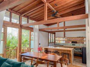 Japanese Villa في كوتا لومبوك: مطبخ بسقوف خشبية وطاولة وكراسي