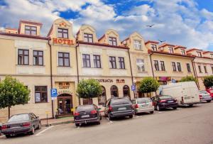 rząd samochodów zaparkowanych przed budynkiem w obiekcie Hotel Vis a Vis Łańcut w Łańcucie