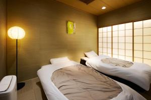 Postel nebo postele na pokoji v ubytování マイグレ南青山