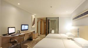 um quarto de hotel com uma cama e uma escrivaninha com um computador em City Comfort Inn Changsha Tangshuili Fuyou em Changsha