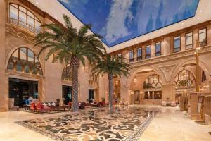 a lobby with palm trees in a building at Great International Hotel in Heyuan