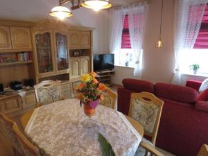 ein Wohnzimmer mit einem Tisch und einer Blumenvase darauf in der Unterkunft FeWo Bergstadt Ehrenfriedersdorf in Ehrenfriedersdorf