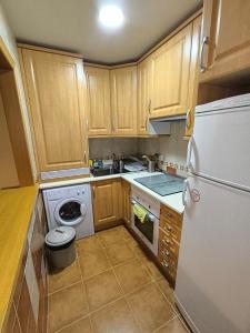 a kitchen with wooden cabinets and a white refrigerator at Apartamento Los Vencejos in Ruidera