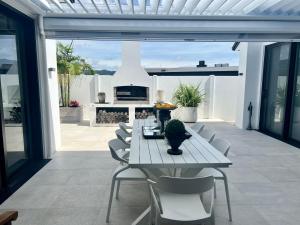 a white table and chairs on a patio with a table at The Waterways Boathouse in Whitianga