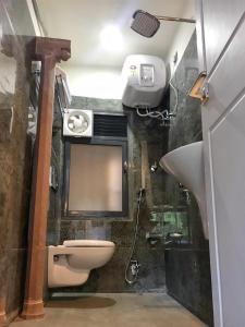 Un baño con lavabo, inodoro y espejo. en VIA VARANASI - A Boutique Hotel at Assi Ghat, en Varanasi 24 fotos más