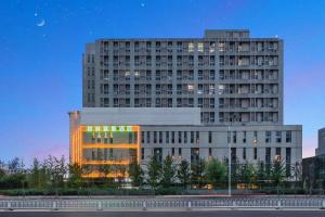 a large building with lights in front of it at GreenTree Inn Beijing Changping District North China Electric Power University Business Hotel in Yongfengtun