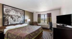 a hotel room with a bed and a flat screen tv at Super 8 By Wyndham Wayne in Wayne